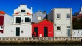 Woman with a red coat in front of a red house in Aveiro, Portugal