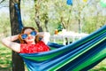 Woman in red dress and big funny sun glasses lying on hammock Royalty Free Stock Photo