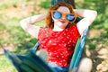 Woman in red dress and big funny sun glasses lying on hammock Royalty Free Stock Photo