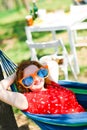 Woman in red dress and big funny sun glasses lying on hammock Royalty Free Stock Photo