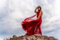 Woman in red dress dance over storm sky, gown fluttering fabric flying as splash Royalty Free Stock Photo