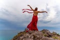 Woman in red dress dance over storm sky, gown fluttering fabric flying as splash Royalty Free Stock Photo