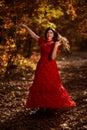 Woman in red dress dancing in the oak forest, full body Royalty Free Stock Photo