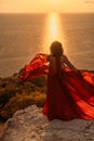 Woman in red dress, fashion model in evening dress, soaring in the street, sunset Royalty Free Stock Photo