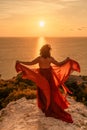 Woman in red dress, fashion model in evening dress, soaring in the street, sunset Royalty Free Stock Photo