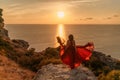 Woman in red dress, fashion model in evening dress, soaring in the street, sunset Royalty Free Stock Photo