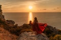 Woman in red dress, fashion model in evening dress, soaring in the street, sunset Royalty Free Stock Photo