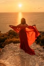 Woman in red dress, fashion model in evening dress, soaring in the street, sunset Royalty Free Stock Photo