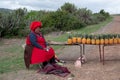 Woman in red dress and hat sells pineapples by the roadside in rural Transkei, South Africa. Royalty Free Stock Photo