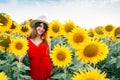 Woman with red dress and hat in sunflowers field