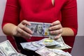 Woman in red dress holding and counting cash money american dollars in her hands on black table background Royalty Free Stock Photo