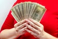 Woman in red dress holding and counting cash money american dollars in her hands. Profit and reward, bribe and graft, wealth Royalty Free Stock Photo