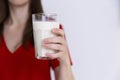 Woman in red dress holding glass of milk. Lactose intolerance, c