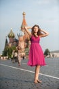 Woman in red dress posing on Red Square in Moscow against St Basil Cathedral Royalty Free Stock Photo