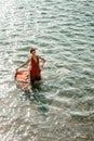 Woman red dress sea. Female dancer in a long red dress posing on a beach with rocks on sunny day Royalty Free Stock Photo