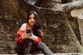 woman in red dress sitting looking at her phone in a park. Royalty Free Stock Photo