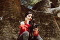 woman in red dress sitting looking at her phone in a park. Royalty Free Stock Photo