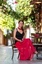 Woman in red dress sitting at a sidewalk cafe Royalty Free Stock Photo