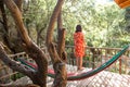 A woman in a red dress stands on the terrace of a wooden house and enjoys the view Royalty Free Stock Photo