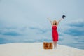 Woman in red dress with suitcase and binoculars Royalty Free Stock Photo