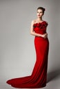 Woman in Red Evening Dress with Flowers Roses, Elegant Fashion Model Beauty Portrait in Long Gown, Studio Portrait