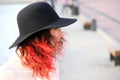 Woman with red hair and a classic black hat with a wide brim. look aside Royalty Free Stock Photo