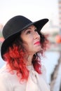 A woman with red hair and a black classic hat with wide fields. look up Royalty Free Stock Photo