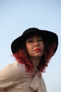 A woman with red hair and a black classic hat with wide fields. after self-isolation