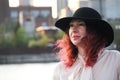 woman with red hair and a classic black hat by the city river Royalty Free Stock Photo