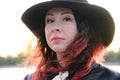 Woman with red hair and a classic black hat with a wide brim. after self-isolation. Royalty Free Stock Photo