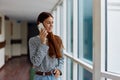 A woman with red hair with a phone in her hands talks and laughs while looking out the window at the city Royalty Free Stock Photo