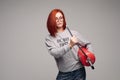 A woman with red hair in the Studio holding a fire extinguisher. An emotional bright woman extinguishes everything with