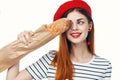 woman in a red hat with a french loaf in her hands a snack Gourmet lifestyle Royalty Free Stock Photo