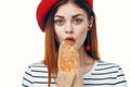 woman in a red hat with a french loaf in her hands a snack Gourmet lifestyle Royalty Free Stock Photo
