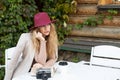 A woman in a red hat sits at a table in a street cafe and writes in a notebook Royalty Free Stock Photo