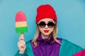 Woman in red hat, sunglasses and suit of 90s with toy ice-cream Royalty Free Stock Photo