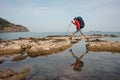 Woman with backpack treks on sea coast