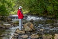 Woman in red jacket by the river