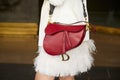 Woman with red leather Dior bag and withe skirt with feathers before Peter Pilotto fashion show