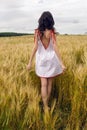 Woman in a red light dress stands in a field Royalty Free Stock Photo