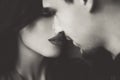 Woman with red lips closing eyes before kissing man black and white sepia