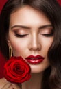 Woman Red Lips with Rose Flower. Beauty Model Face Makeup with Closed Eyes. Fashion Brunette Girl Close up Portrait over Red Royalty Free Stock Photo