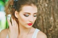 Woman with red lipstick and colored makeup, portrait in nature. Looking to the side. His eyes covered.