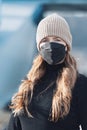 Woman with red long hair, blue eyes, young with FFP2 mask, wearing beige cap and black sweater, head portraits Royalty Free Stock Photo