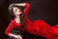 Woman in red lying in the dark. Fashion tempting girl model in s Royalty Free Stock Photo