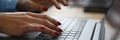 Woman with red nails is typing on keyboard.