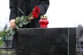 Woman with red roses, focus on candle. Funeral ceremony Royalty Free Stock Photo