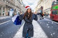 Woman with red Santa hat and many shopping bags on Regent Street in London, UK Royalty Free Stock Photo