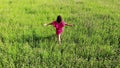 Woman in red sexy dress walking by green field, raise up hands, happy inspirational freedom concept, beauty, shot from