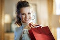 Woman with red shopping bag in modern house in sunny winter day